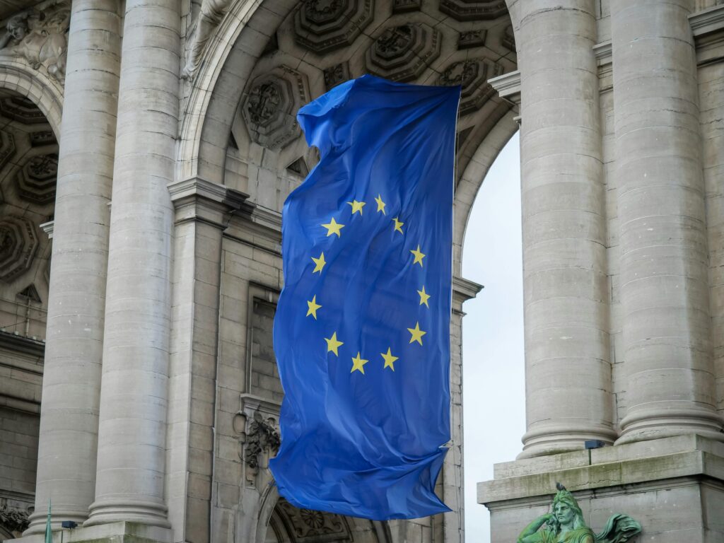 European Union flag fluttering beneath the Cinquantenaire Arch in Brussels, Belgium.